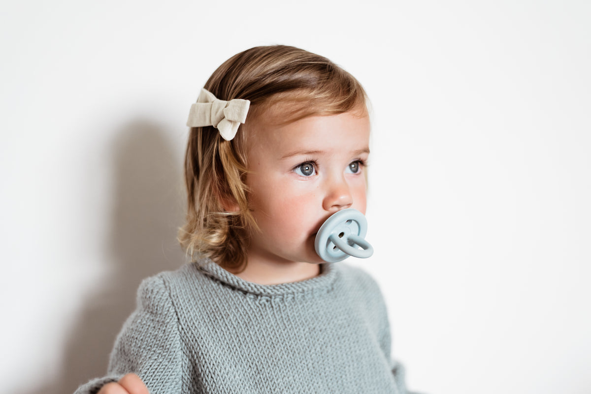 Toddler smiling while playing with a wooden toy